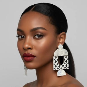 Pode incluir: Brincos geom&eacute;tricos prateados e pretos com um padr&atilde;o texturizado. Os brincos t&ecirc;m um design arrojado com uma mistura de formas, incluindo um semic&iacute;rculo, um ret&acirc;ngulo e um semic&iacute;rculo menor.