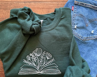 Broderad tröja med rund halsringning och bok med blommor