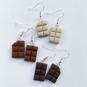 Chocolate bar earrings
white background
White chocolate bars
Milk chocolate bars
Dark chocolate bars
Single small bite out of the chocolate bars