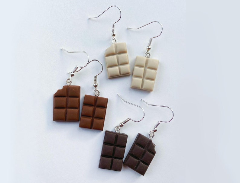 Chocolate bar earrings
white background
White chocolate bars
Milk chocolate bars
Dark chocolate bars
Single small bite out of the chocolate bars