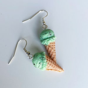 Mint chocolate chip ice cream dangle earrings on a white background.