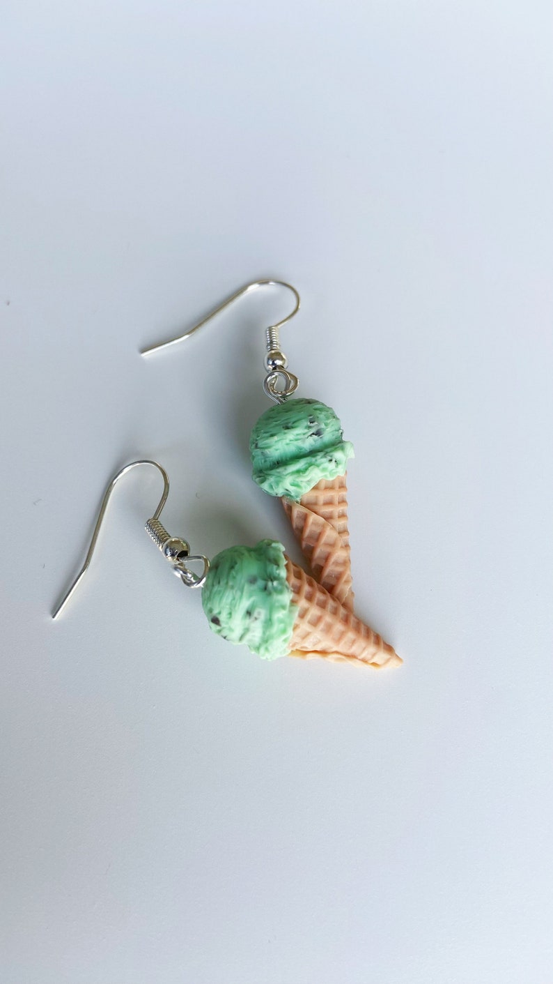 Mint chocolate chip ice cream dangle earrings on a white background.