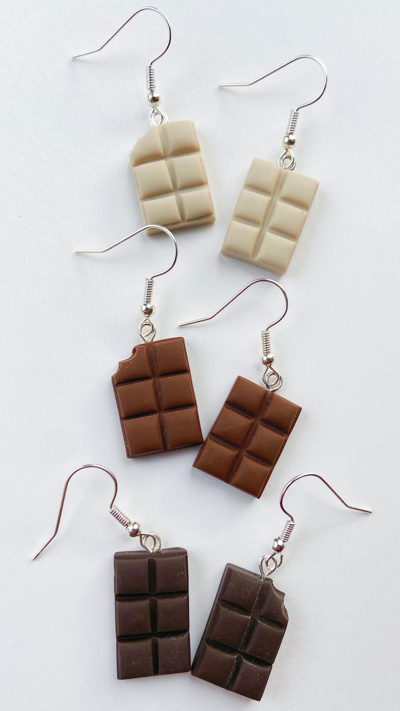 Chocolate bar earrings stacked
white background
White chocolate bars
Milk chocolate bars
Dark chocolate bars
Single small bite out of the chocolate bars