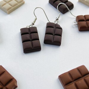 Dark chocolate bar earrings surrounded by white and milk chocolate bar charms.