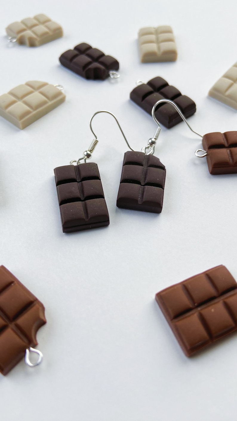 Dark chocolate bar earrings surrounded by white and milk chocolate bar charms.