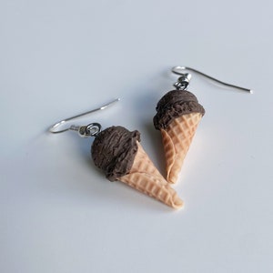 Chocolate ice cream dangle earrings on a white background.