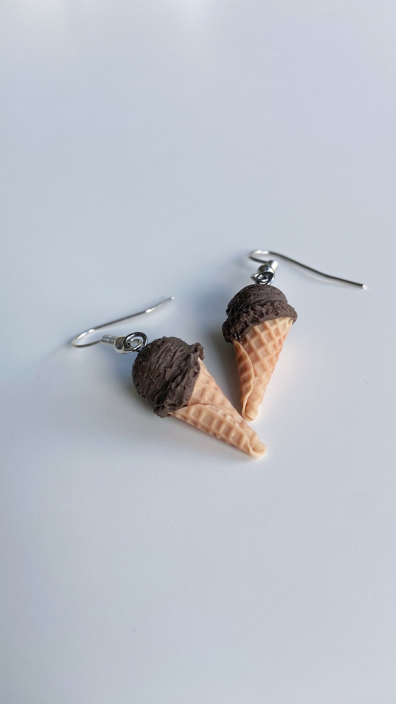 Chocolate ice cream dangle earrings on a white background.