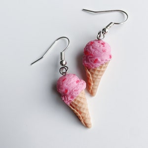 Strawberry ice cream dangle earrings on a white background.