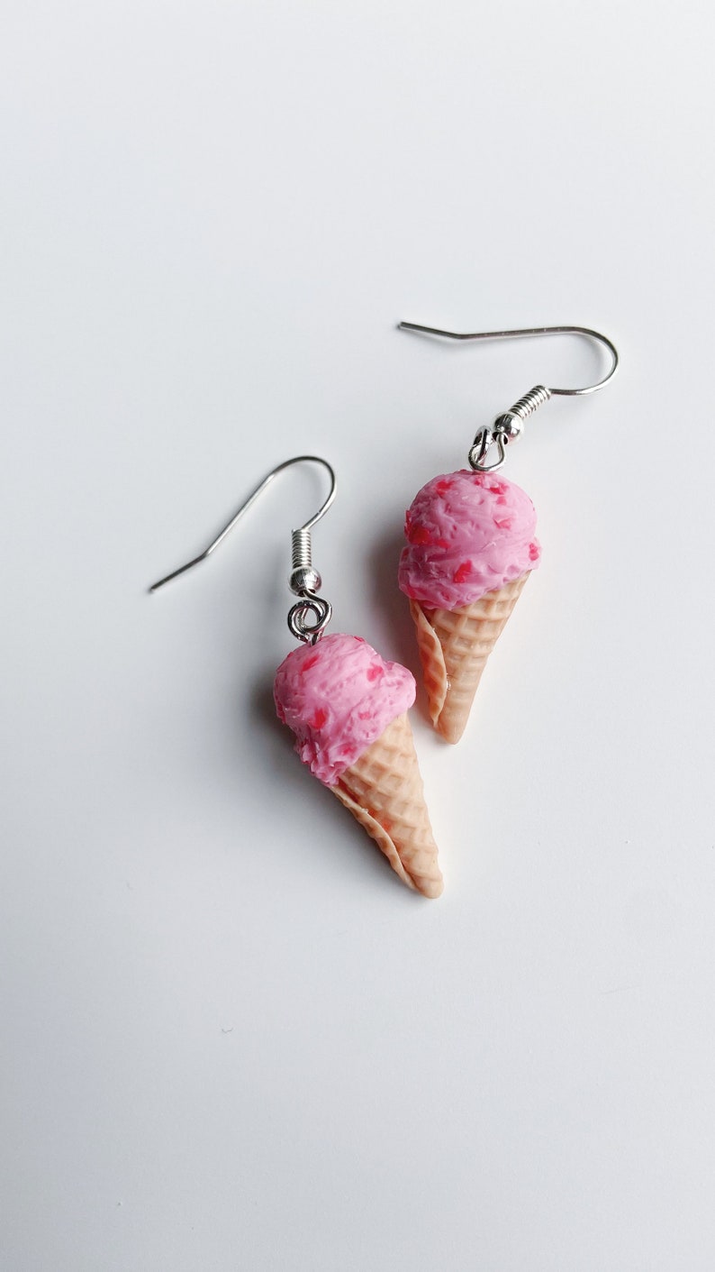 Strawberry ice cream dangle earrings on a white background.