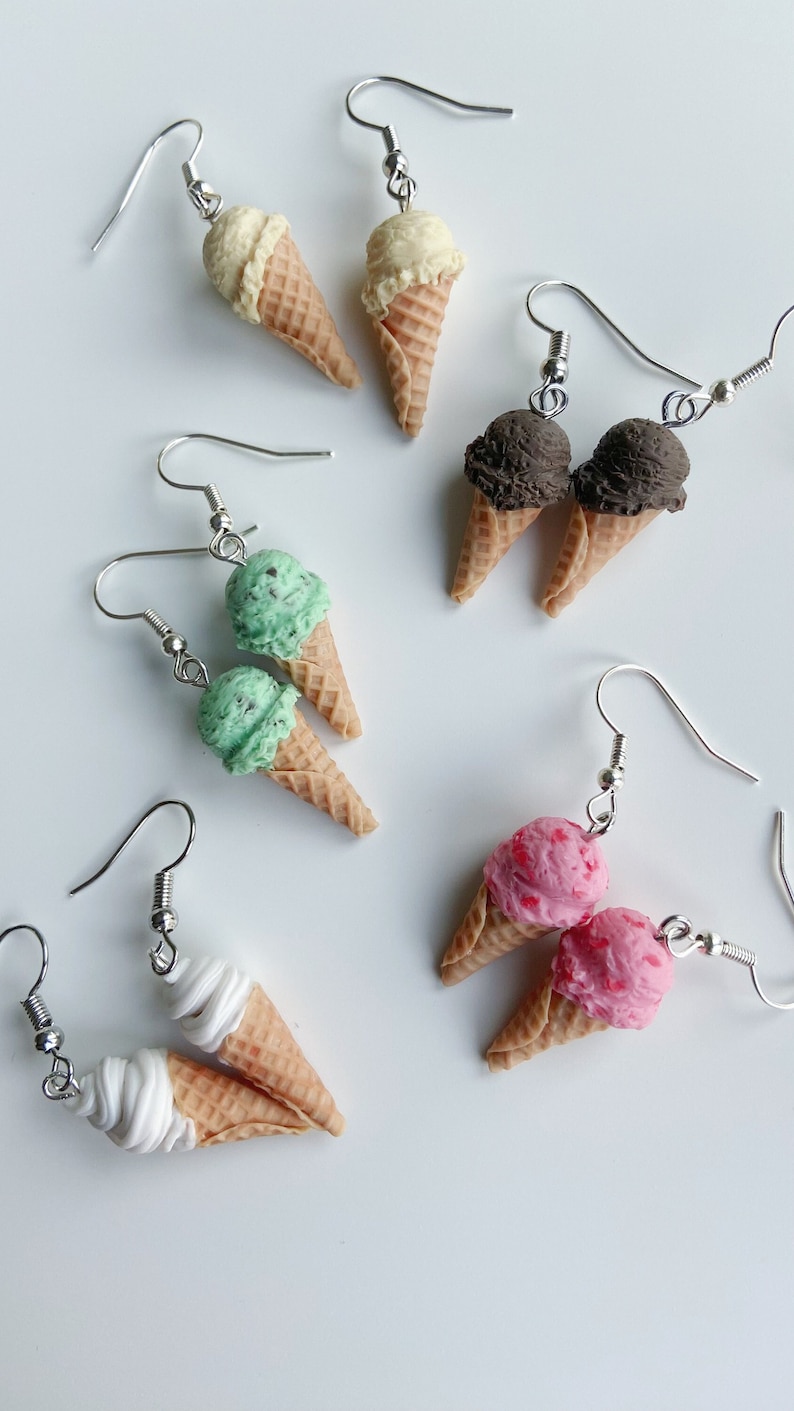 Ice cream dangle earrings on a white background. Strawberry icecream, chocolate ice cream, softserve icecream, vanilla ice cream and mint chocolate chip icecream. Scooped ice cream cones and soft serve ice cream cones.