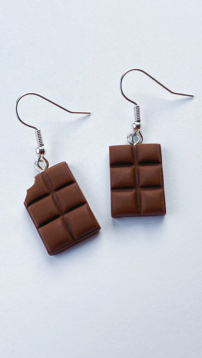 Milk chocolate bar dangle earrings. Left chocolate bar is missing a tiny bite of the chocolate in the top corner.