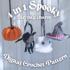 May include: A set of four crocheted Halloween-themed charms for cars or bags. The set includes an orange pumpkin, a black spider, a white ghost, and a grey witch's hat with pink trim. The image text reads "4 in 1 Spooky car/bag charm" and "Digital Crochet Pattern."