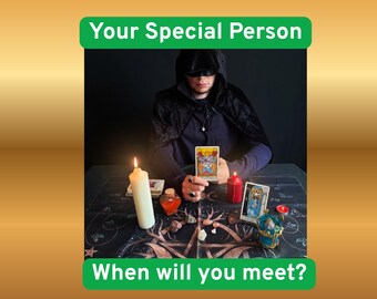 Puede incluir: Una persona con capa negra con capucha sostiene una carta del tarot en una mesa con una vela blanca, una vela roja, una pequeña botella naranja, cristales y un paño negro con arte lineal blanco. Texto: Your Special Person When will you meet?