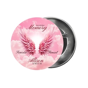 May include: A pink button with a pair of angel wings and the text "In Loving Memory" with the name "Alison Smith" and the words "Sunrise" and "Sunset" on a pink cloudy background.