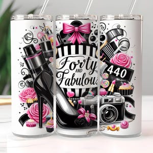 May include: White tumbler with a pink and black design featuring a high heel shoe, a camera, and the text "Forty and Fabulous 440".
