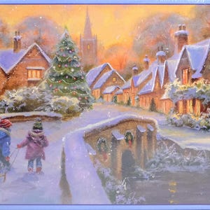 May include: A jigsaw puzzle box featuring a winter village scene at sunset with snow-covered stone cottages, a decorated Christmas tree, and a stone bridge. Two children in winter coats and hats pull a small wooden sled with gifts across the snow.