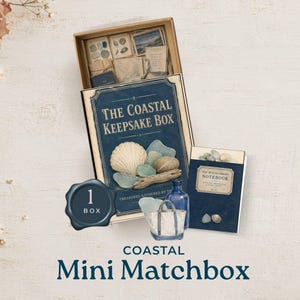 May include: A Coastal Keepsake Box set featuring a dark blue box with a shell and driftwood graphic, a matching Beachcomber's Notebook, and a small blue glass bottle. The open box contains various small paper cards, shells, and sea glass pieces.
