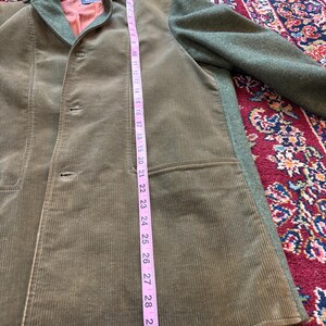 K&ouml;nnte beinhalten: Eine olivgr&uuml;ne Cordjacke mit einem Kragen und &Auml;rmeln aus gr&uuml;nem Wollstoff. Die Jacke hat einen Dreiknopfverschluss und eine Tasche. Die L&auml;nge der Jacke betr&auml;gt ca. 76 cm.