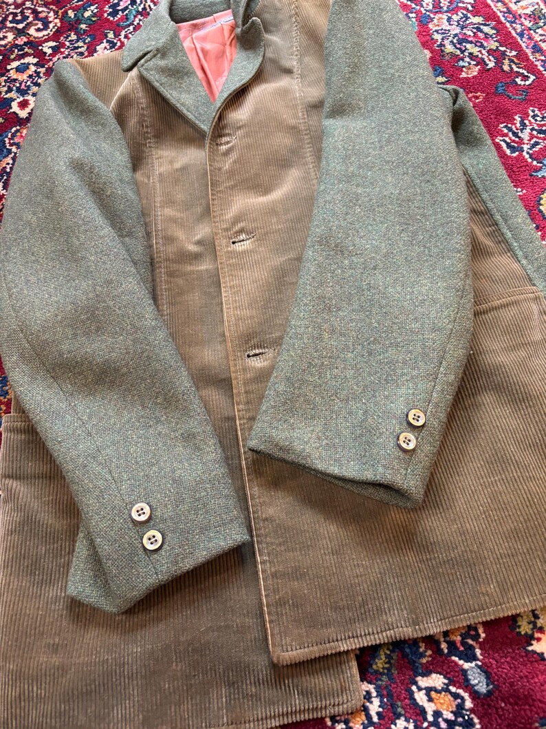 K&ouml;nnte beinhalten: Vintage Cordjacke mit gr&uuml;nen Tweed&auml;rmeln und Kragen. Die Jacke hat eine ged&auml;mpfte olivgr&uuml;ne Farbe mit einem Dreiknopfverschluss und zwei Kn&ouml;pfen an jeder &Auml;rmelmanschette. Das Innenfutter ist lachsrosa.