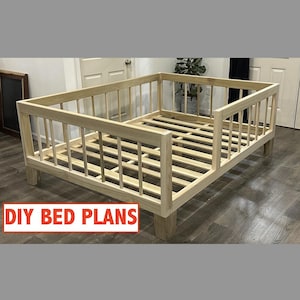 May include: A light-colored wooden bed frame with a slatted base and a railing on three sides. The frame is rectangular with four sturdy legs. The text "DIY BED PLANS" is displayed in a red box at the bottom.