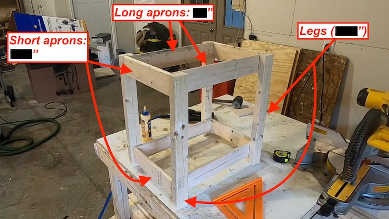 Op de afbeelding: Een houten frame voor een tafel met vier poten en vier korte schorten. Het frame is gemaakt van onbehandeld hout en staat op een werkbank. De tekst "Short aprons: " en "Long aprons: " staat op de afbeelding.