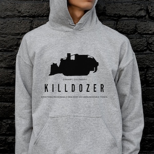 May include: Grey hooded sweatshirt with a black silhouette of a bulldozer and the text "KILLDOZER" and "GRANBY, COLORADO" and "SOMETIMES REASONABLE MEN MUST DO UNREASONABLE THINGS".