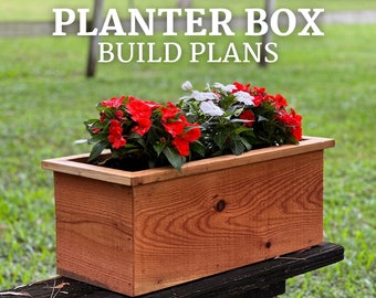 May include: A wooden planter box filled with red and white flowers. The planter box is made from cedar wood and has a natural finish. The planter box is sitting on a wooden bench. The text "PLANTER BOX BUILD PLANS" is displayed above the planter box.