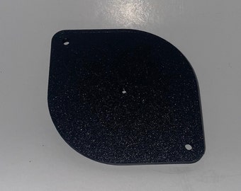 May include: A black plastic, oval-shaped, blank plate with two small holes.