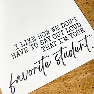 May include: A white card with black text that reads "I like how we don't have to say out loud that I'm your favourite student."