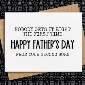 May include: A white card with black text that reads "Nobody gets it right the first time. Happy Father's Day from your second born." The card is on a brown background with a black and white pattern.