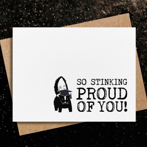 May include: A black and white illustration of a skunk wearing a graduation cap. The text "So Stinking Proud Of You!" is written below the skunk.