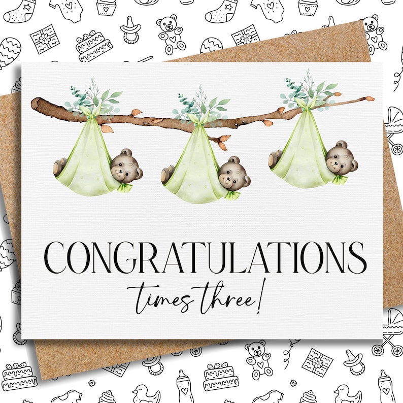 K&ouml;nnte beinhalten: Eine Gru&szlig;karte mit einem Kraftpapierumschlag zeigt eine Aquarellillustration. Drei Teddyb&auml;ren liegen in hellgr&uuml;nen Windeln, die an einem Ast h&auml;ngen. Der Text "CONGRATULATIONS times three!" ist in schwarzer Schrift geschrieben.
