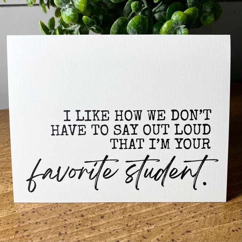 May include: A white card with black text that reads "I like how we don't have to say out loud that I'm your favourite student."