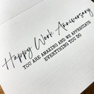 以下が含まれることがあります： 白いカードに黒い文字で「Happy Work Anniversary. You are amazing and we appreciate everything you do.」と書かれています。