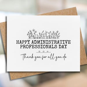 May include: A white greeting card with the text "HAPPY ADMINISTRATIVE PROFESSIONALS DAY" and "Thank you for all you do." The card has a floral design at the top and is on a brown envelope.