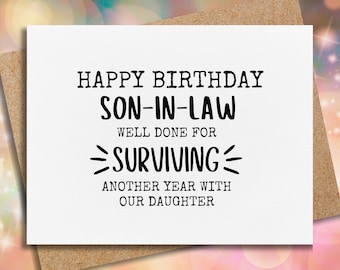 May include: A white card with black text that reads "Happy Birthday Son-in-Law Well Done For Surviving Another Year With Our Daughter".