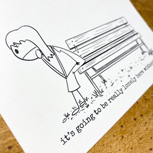 May include: Monochrome illustration of a person near a park bench. The person is looking down, with the text "it's going to be really lonely here without" printed below the bench.