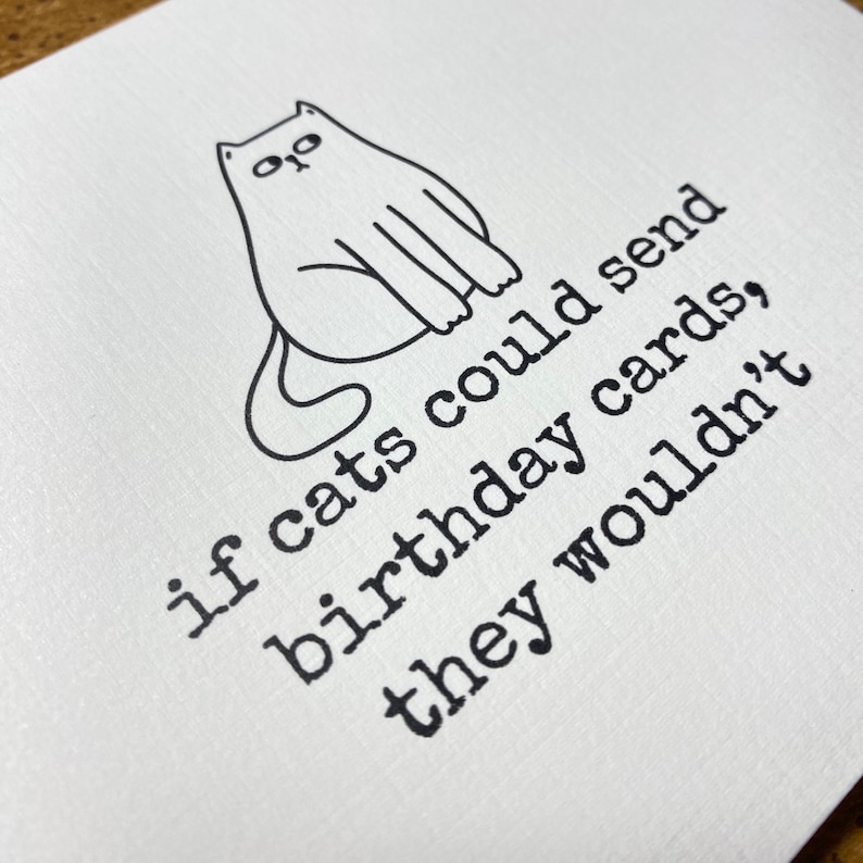 May include: A black and white illustration of a cat sitting with the text "if cats could send birthday cards, they wouldn't"