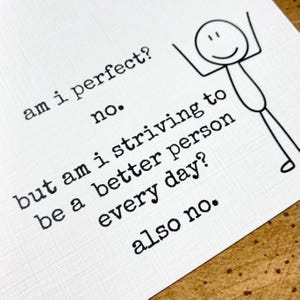May include: A white card with black text that reads: am i perfect? no. but am i striving to be a better person every day? also no. Next to the text is a simple black line drawing of a stick figure with arms raised in a cheerful pose.