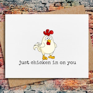May include: A white greeting card with a cartoon chicken illustration and the text "just chicken in on you".