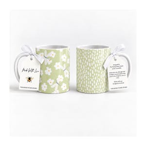 two mugs with different floral designs, one with white flowers and the other with white dots.