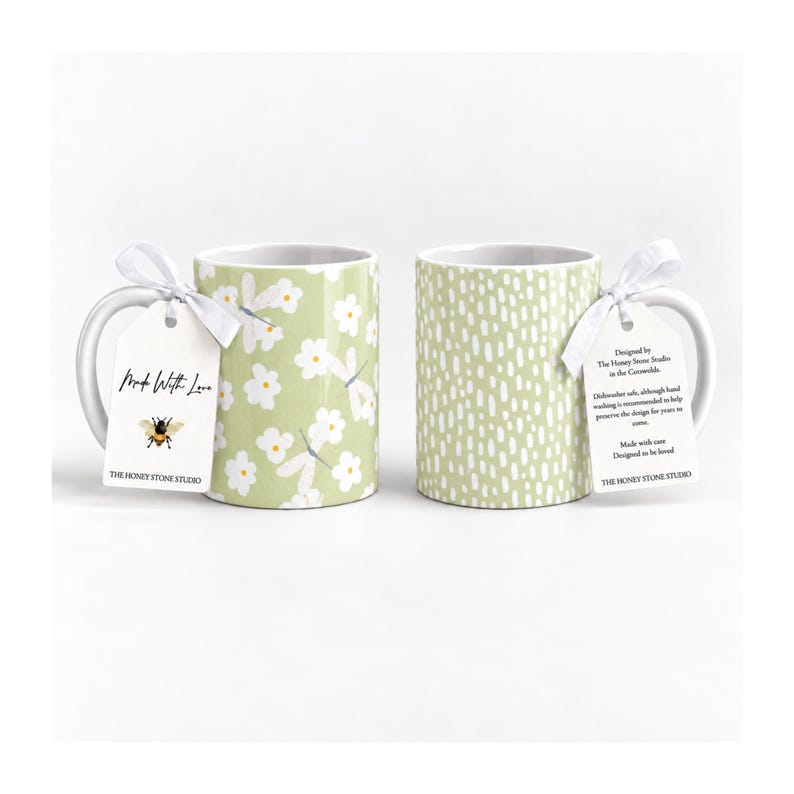 two mugs with different floral designs, one with white flowers and the other with white dots.