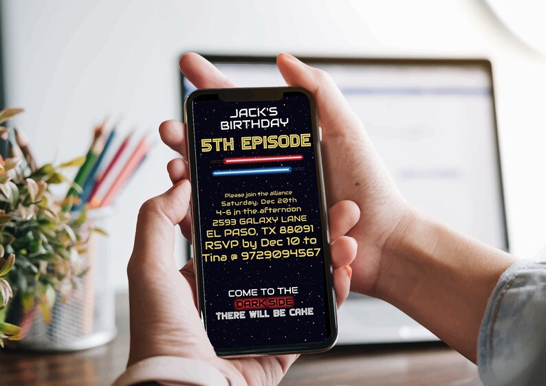 May include: A smartphone displaying a Star Wars themed birthday invitation for Jack's 5th birthday party. The invitation features a dark blue background with yellow text and red and blue lightsabers. The text reads "Jack's Birthday 5th Episode" and includes details about the party, including the date, time, location, and RSVP information. The invitation also includes the text "Come to the Dark Side There will be cake."