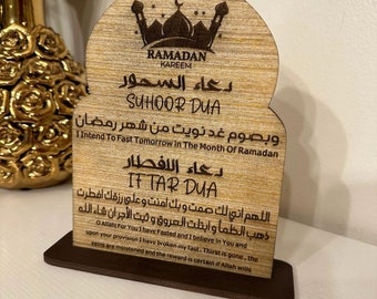 May include: A wooden plaque with a decorative arch design, featuring the words "Ramadan Kareem" and Arabic text. The plaque includes two prayers, "Suhoor Dua" and "Iftar Dua", with English translations below.