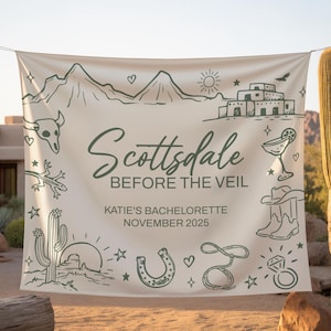 May include: A cream-colored banner with the words "Scottsdale Before The Veil" and "Katie's Bachelorette November 2025" in green. The banner features desert-themed illustrations, including cacti, a horseshoe, and a cowboy hat.
