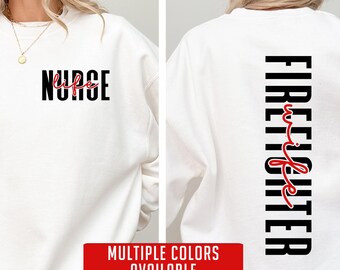 May include: White sweatshirt with black text that reads "Firefighter wife" in a vertical orientation. The word "wife" is in red cursive. The sweatshirt is available in multiple colors.