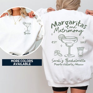 May include: White sweatshirt with a green graphic of a margarita and the text "Margaritas and Matrimony EST 2025" and "Sarah's Bachelorette Puerto Vallarta, Mexico". The front of the sweatshirt has a smaller green graphic of a margarita with the word "Bride".