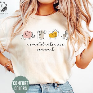 May include: A white t-shirt with a graphic of a pink elephant, a brown koala, a yellow lion, and a black and white zebra. The text "neonatal intensive care unit" is printed below the graphic.