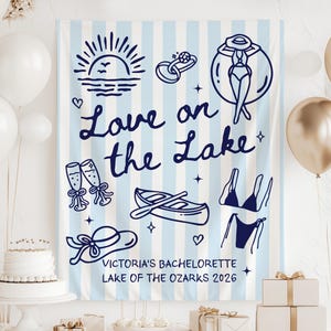 May include: A blue and white striped banner with navy blue illustrations of a sun, ring, woman in a swimsuit, champagne flutes, boat, hat, and bikini. Text reads "Love on the Lake" and "Victoria's Bachelorette Lake of the Ozarks 2026".