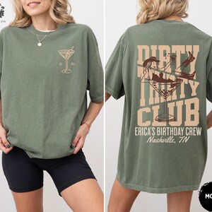 May include: Green t-shirt with the text "Dirty Thirty Club" and a martini glass graphic. The text "Erica's Birthday Crew Nashville, TN" is printed below the graphic.